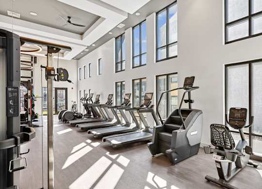 A gym with treadmills, elliptical machines, and other exercise equipment.