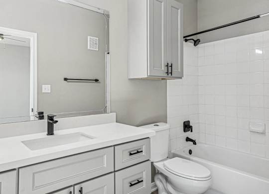 A white bathroom with a sink, toilet, and bathtub at Clear Creek Meadows Apartments, Apartments, Copperas Cove, TX