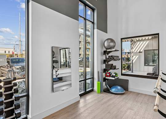 A room with a mirror, a ball, and a bench.