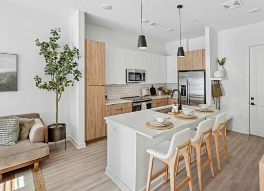 A modern kitchen with a dining area and a living room.