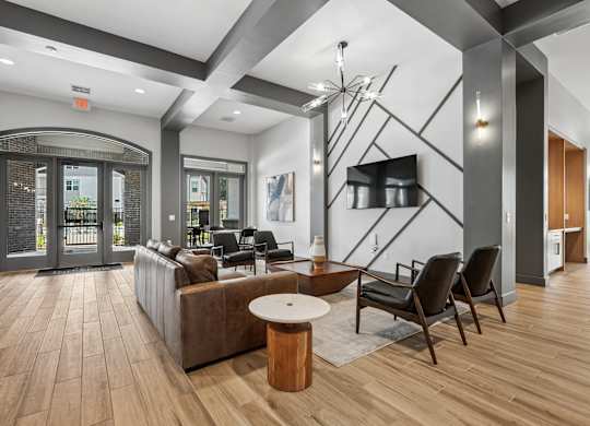 A modern waiting room with a wooden floor and black and white decor.
