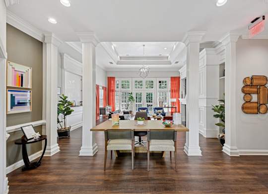 A large room with a long table and chairs in the middle.