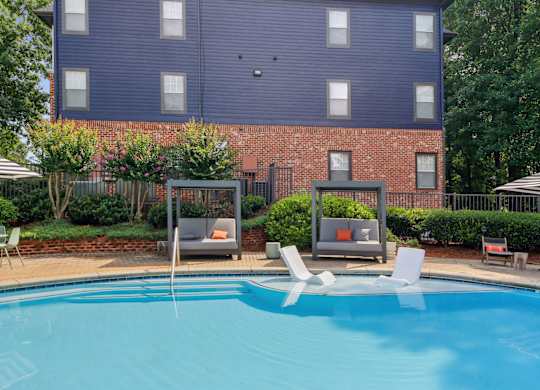 A blue swimming pool in front of a brick building.