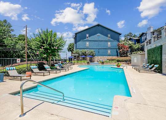 A blue building with a pool in front of it.