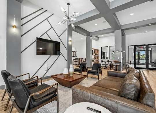 A modern living room with a brown leather couch and a television mounted on the wall.