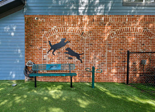 A dog silhouette is painted on a brick wall.