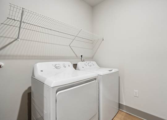 A white washing machine and dryer in a small room.