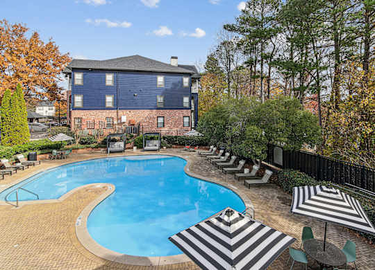 A large blue building with a pool in front.