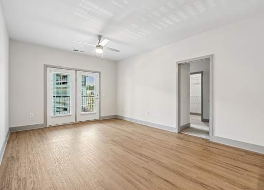 A room with a wooden floor and a ceiling fan.