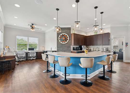A kitchen with a blue counter and white chairs.