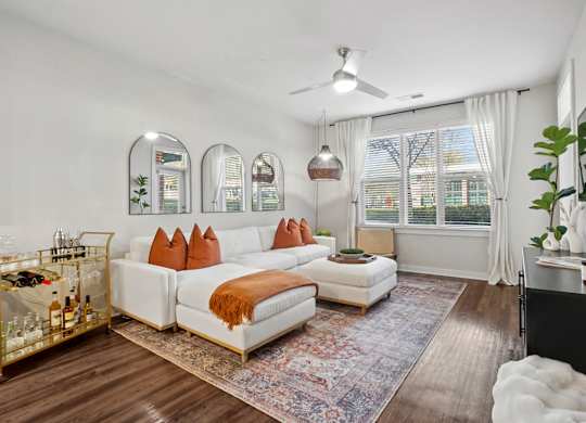 A living room with a white couch and a rug.