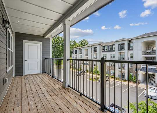 A balcony with a white door and a black railing.