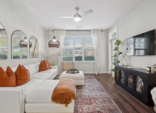 A living room with a white couch and a rug.