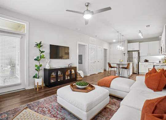 A living room with a white couch and a wooden coffee table.
