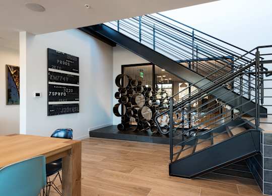 A modern staircase with a metal railing and wooden steps.at Axle, Seattle Washington 