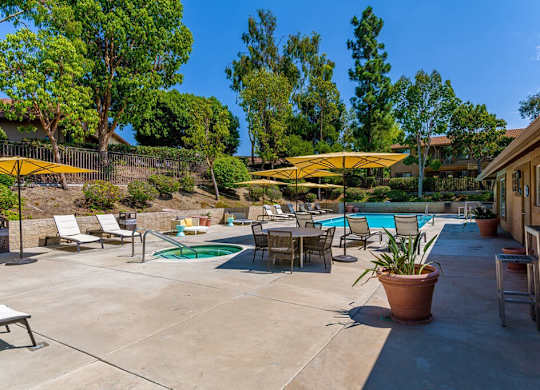 A pool area with a green pool and a yellow umbrella.