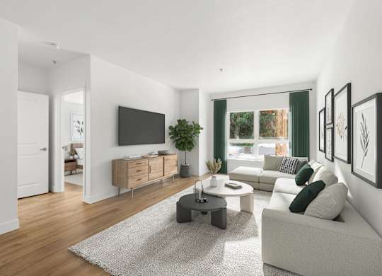 A modern living room with a white couch, a grey rug, and a wooden floor.