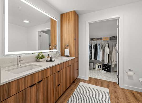 A bathroom with a sink, mirror, and wooden cabinets.