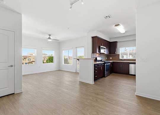 A spacious kitchen with wooden floors and white walls.