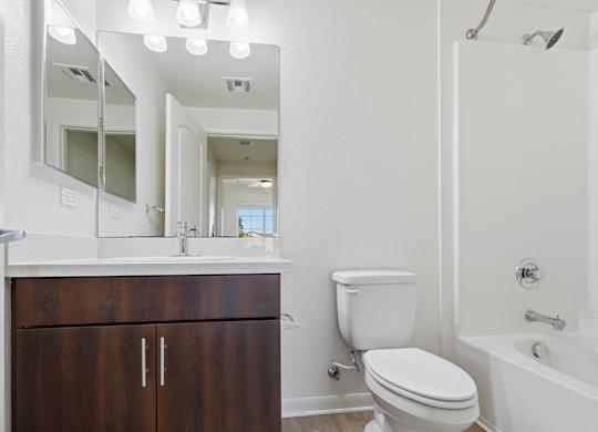 A white toilet sits next to a white sink in a bathroom.