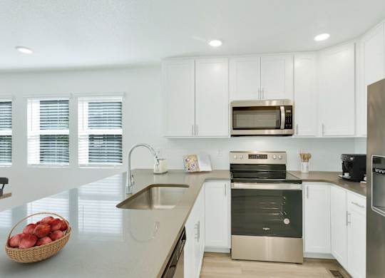 a kitchen with white cabinets and stainless steel appliances