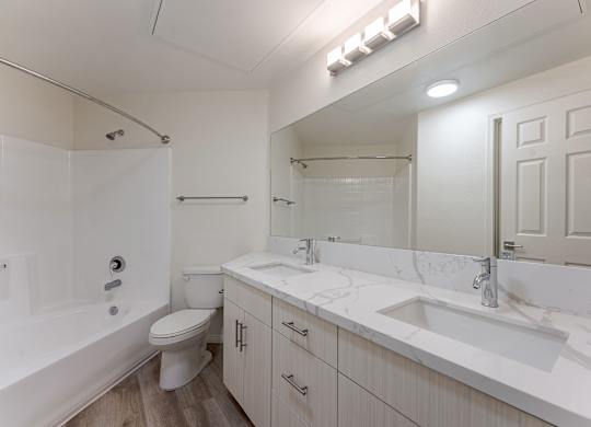 A white bathroom with a toilet, sink, and bathtub.