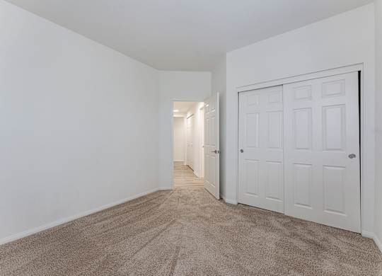 A room with a carpeted floor and a white door.