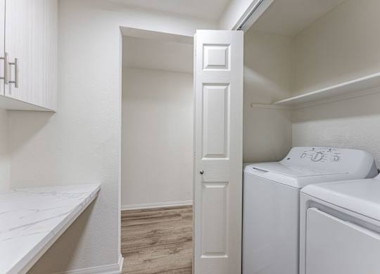 A white door is open to a laundry room.