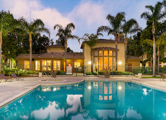A house with a pool in front of it.