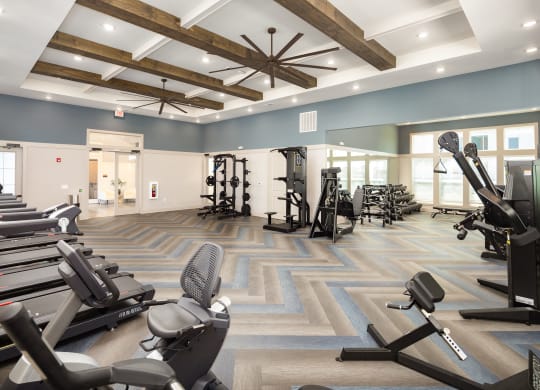 a gym with cardio machines and weights on the floor