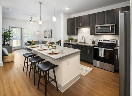 an open kitchen and living room with an island and bar stools