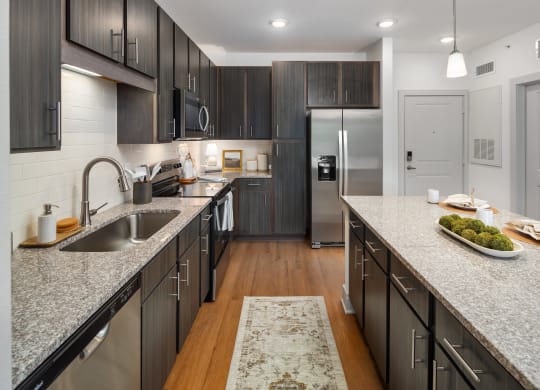 a large kitchen with granite counter tops and stainless steel appliances