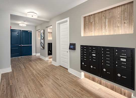 a view of a hallway with a large locker wall and a door to a closet
