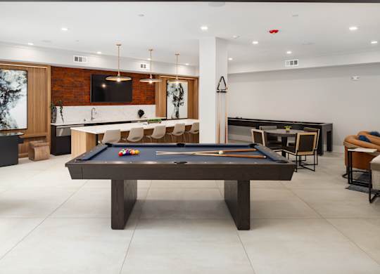 an open living room with a pool table and a bar