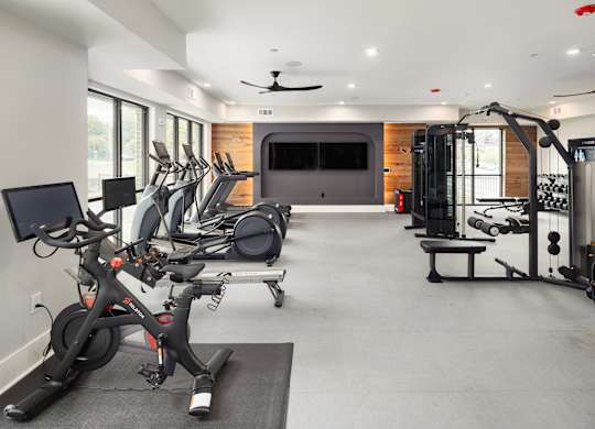a gym with exercise equipment and a tv in the back