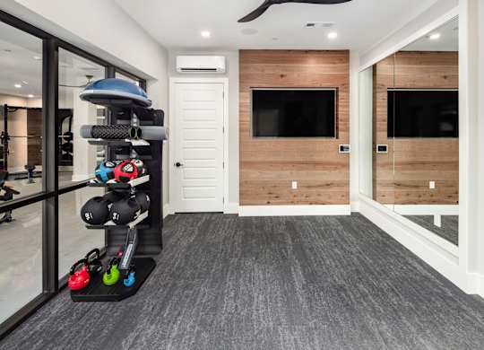 a home gym with weights and a tv on the wall