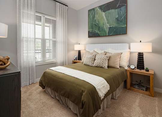 a bedroom with a bed and a large green painting