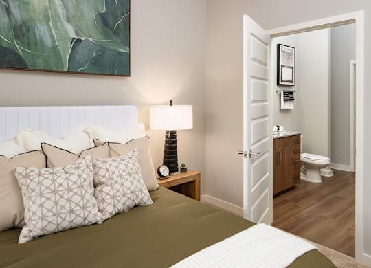 a bedroom with a bed and a bathroom with a toilet
