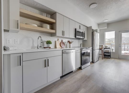 an open kitchen with white cabinets and stainless steel appliances
