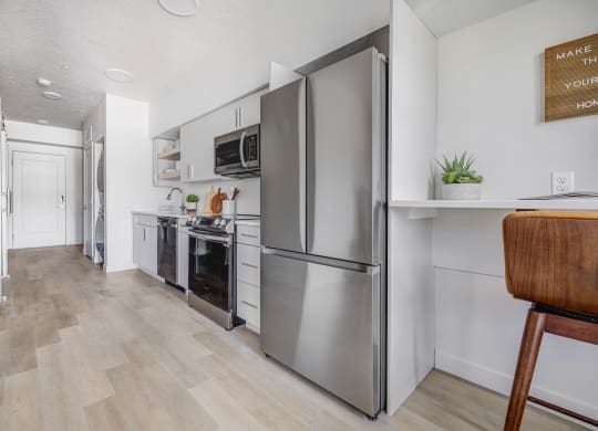 a kitchen with stainless steel appliances and a wooden floor