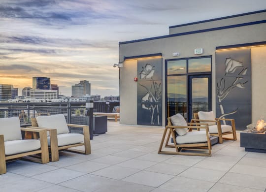 a roof deck with chairs and a view of the city