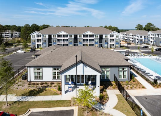 an aerial view of a building with a swimming pool and other buildings