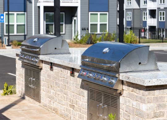 two bbq pits on a brick wall in front of a building