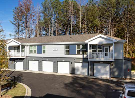 A two-story house with a garage and a driveway.
