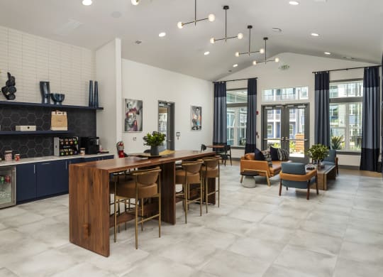 a communal area with a bar and chairs and a living room with a couch