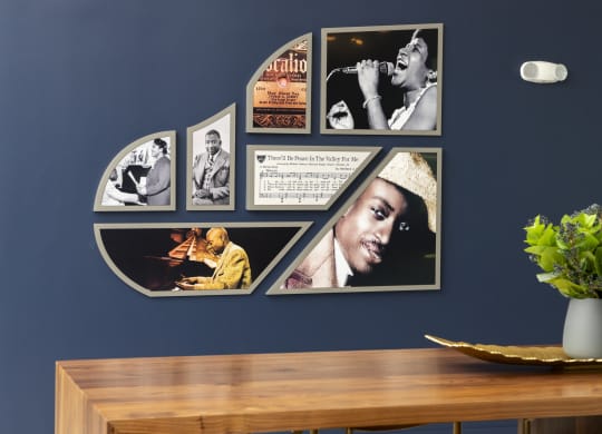a wall with various pictures on it and a table with a plant