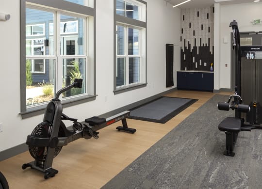 a gym with exercise equipment and windows in a building