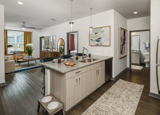 a kitchen and living room with a refrigerator and a sink