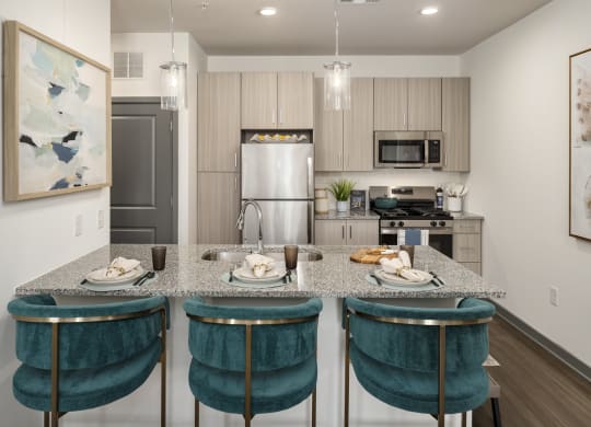 a kitchen with an island with blue chairs and a granite counter top
