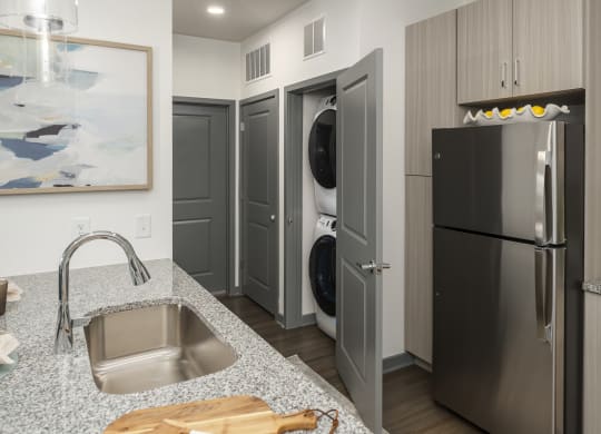 a kitchen with stainless steel appliances and a sink and a washer and dryer